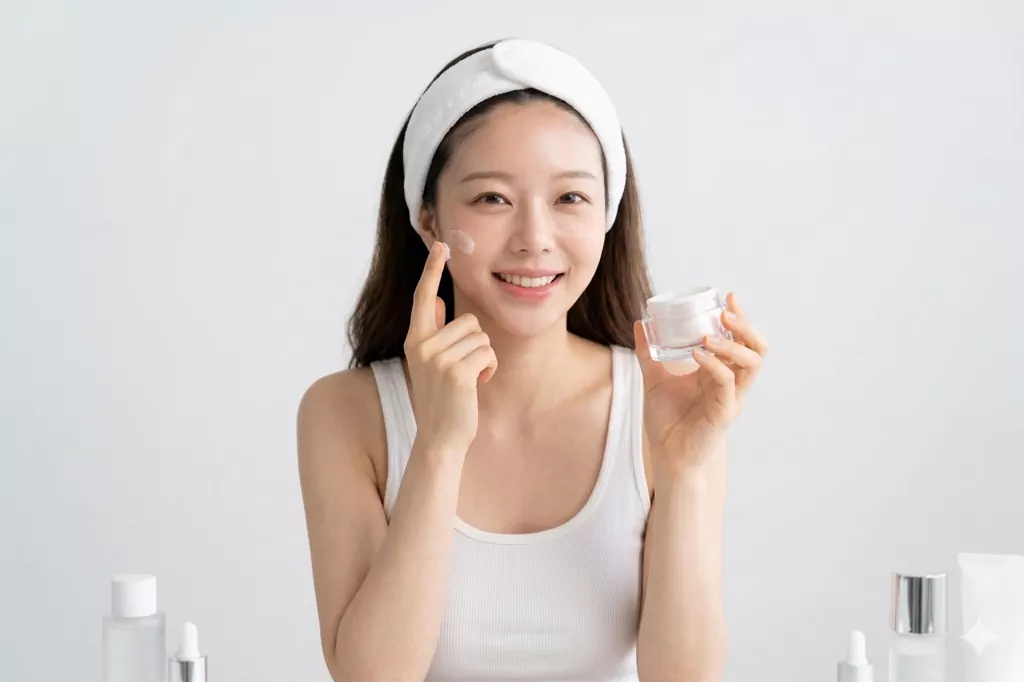 Post-Cleansing Habits That Are Sabotaging Your K-Beauty Glow (Bestie, Don’t Miss the 3-Second Window!) 2 A woman with radiant skin applying moisturizer, showcasing the successful result of mastering the right post-cleansing habits.