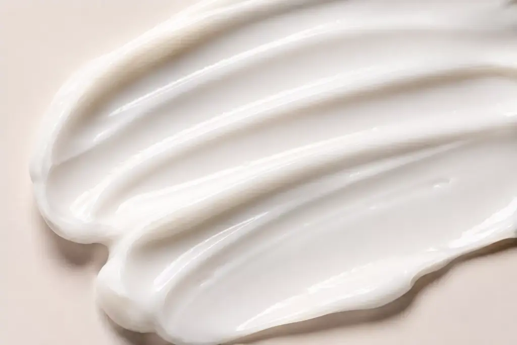 Centella vs Panthenol: Which Barrier Restorer Actually Heals Your Skin? 2 A close-up shot of a rich, white cosmetic cream texture being swatched, highlighting a moisture barrier repair product for Centella vs Panthenol comparison.