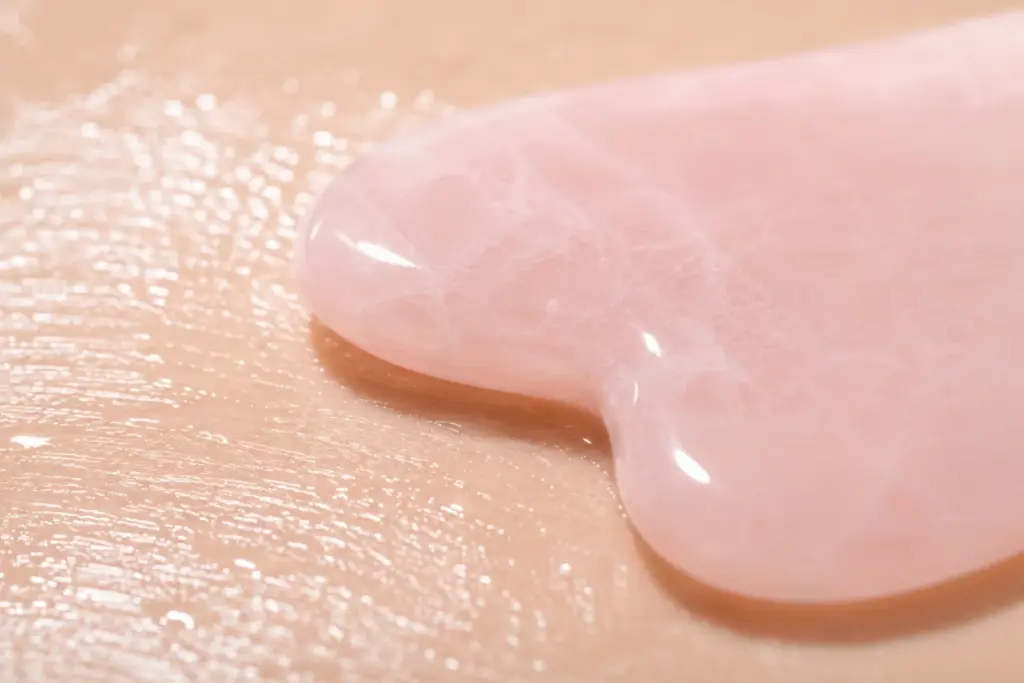 K-Beauty Gua Sha Routine: How to Lift Your Jawline Without Damaging Skin 3 A barrier-safe 15-degree tool angle applied over a silky serum layer during a K-Beauty Gua Sha routine.
